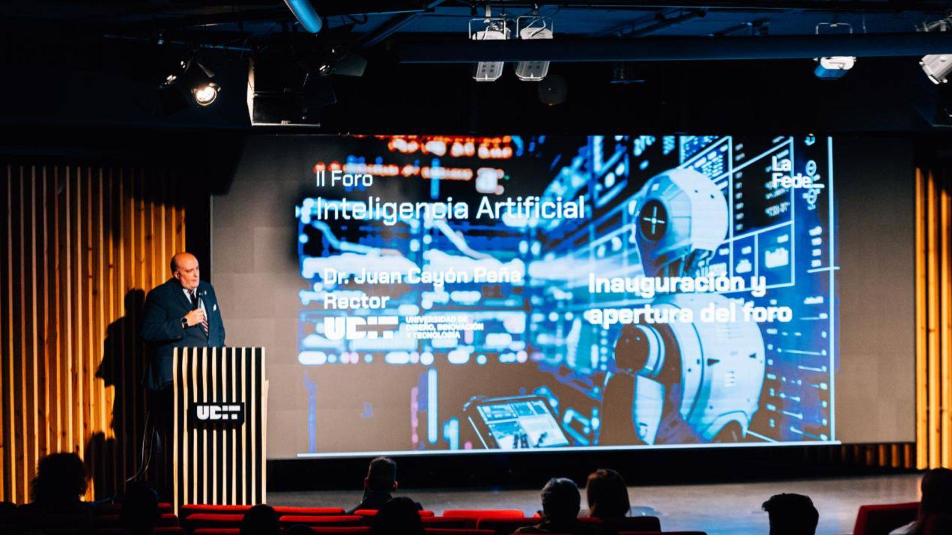 Un ponente presenta un foro sobre inteligencia artificial con tecnología visual en la pantalla de fondo.