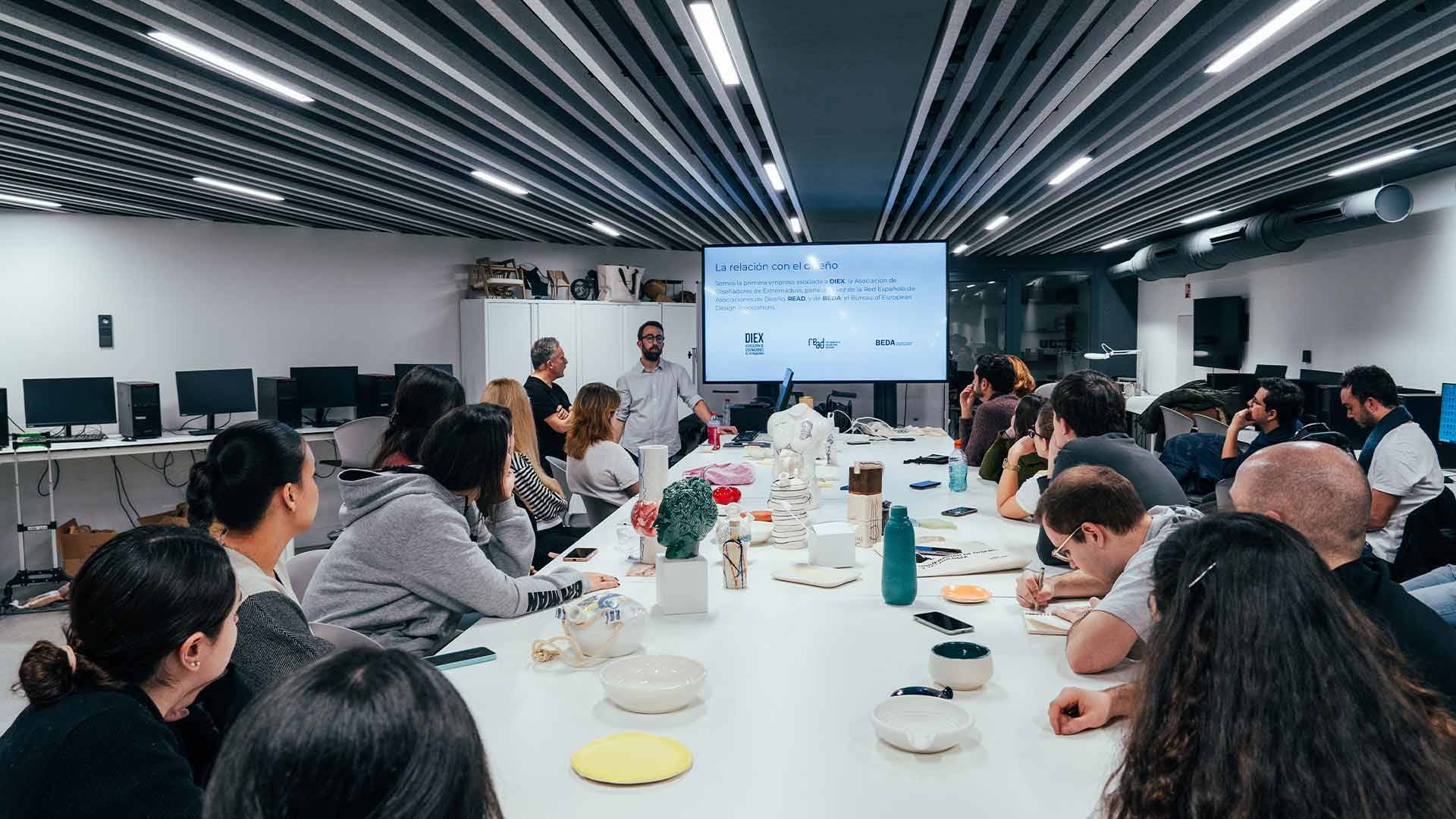 Una reunión grupal en un ambiente moderno con una presentación en pantalla.