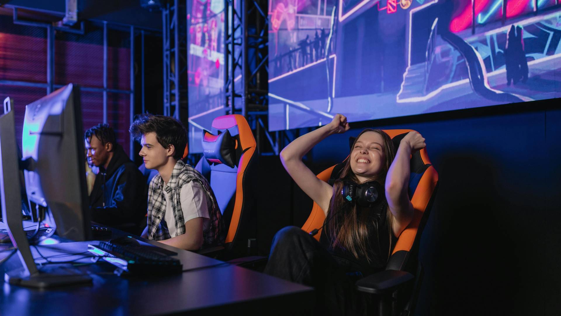Un grupo de jóvenes se divierte jugando en una sala de videojuegos.
