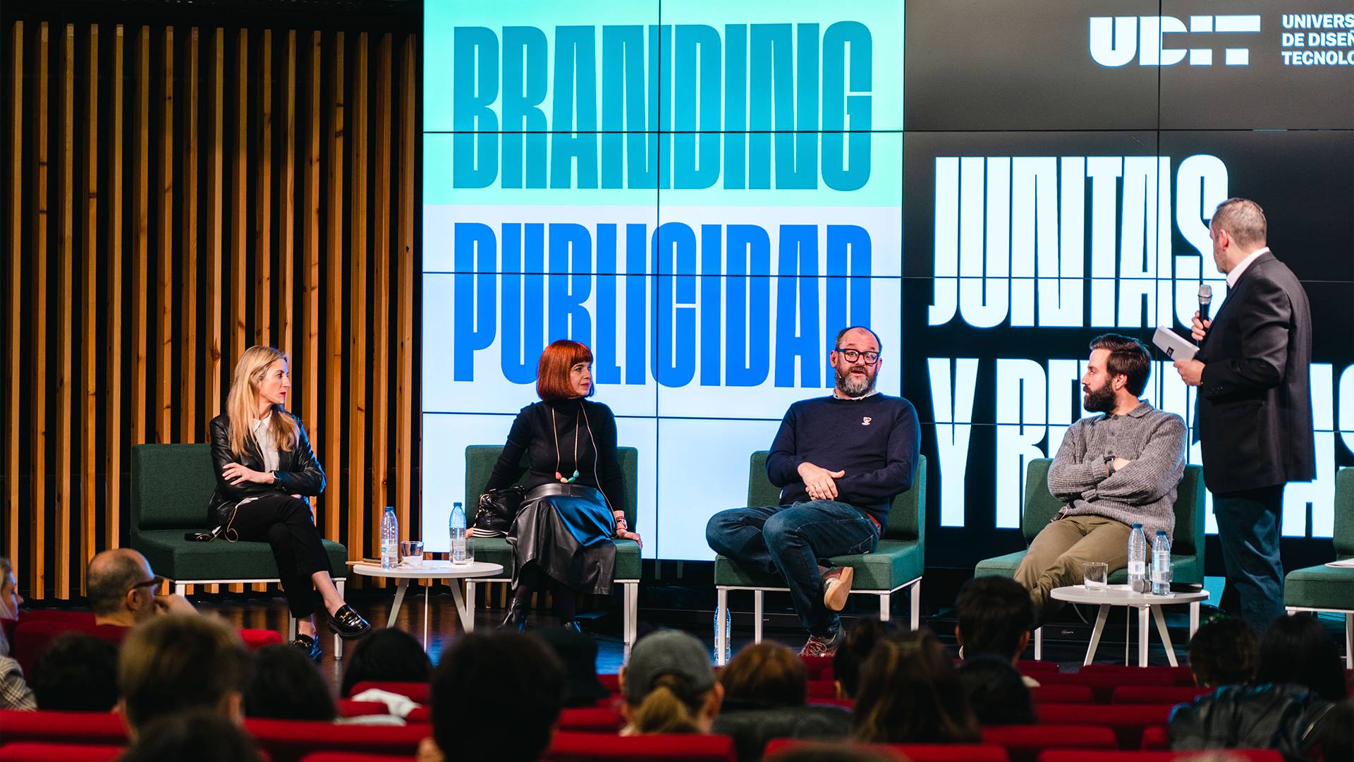 Un panel de discusión sobre branding y publicidad en un evento universitario.