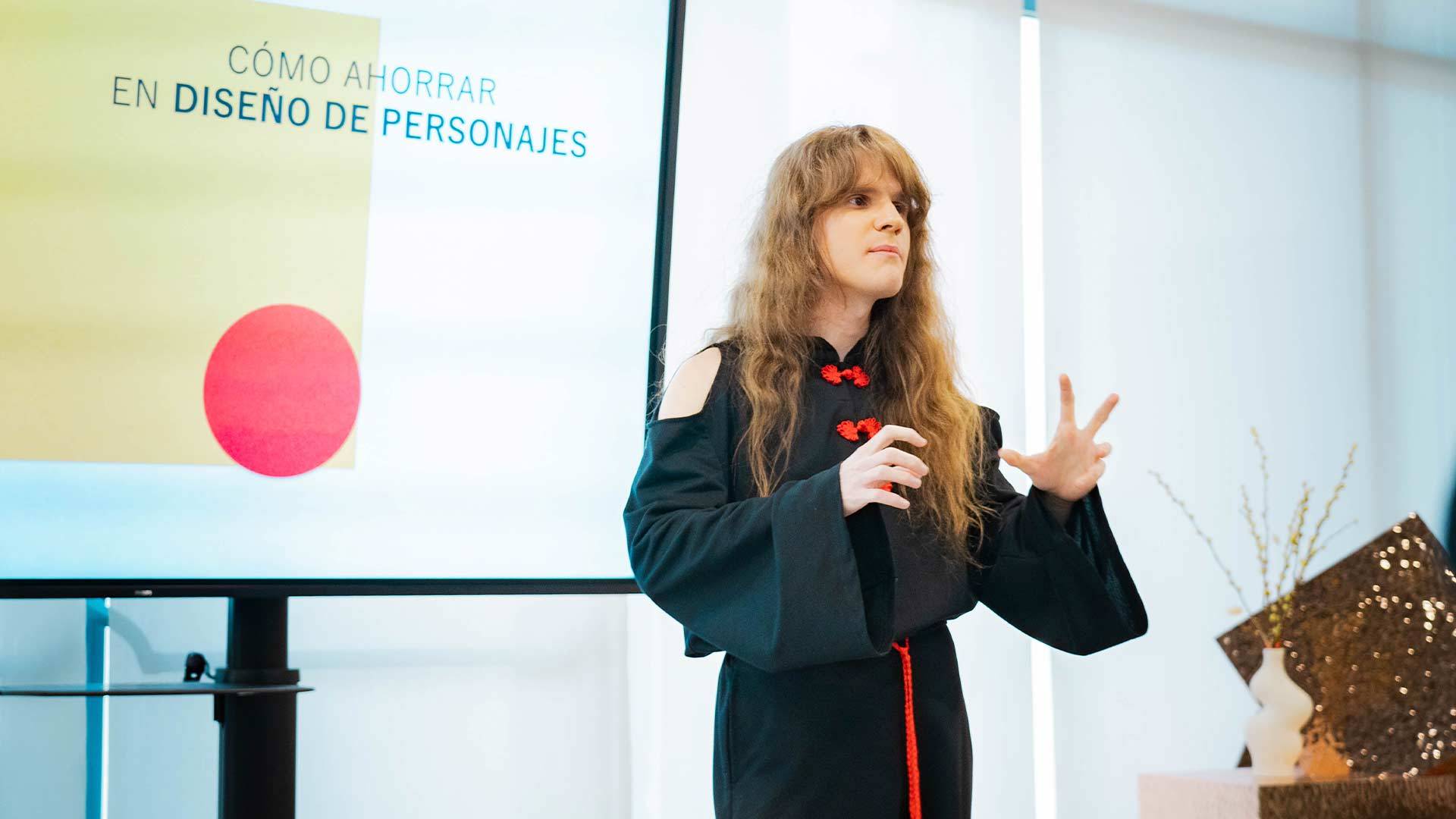 Una persona presenta un tema sobre diseño de personajes en una conferencia.