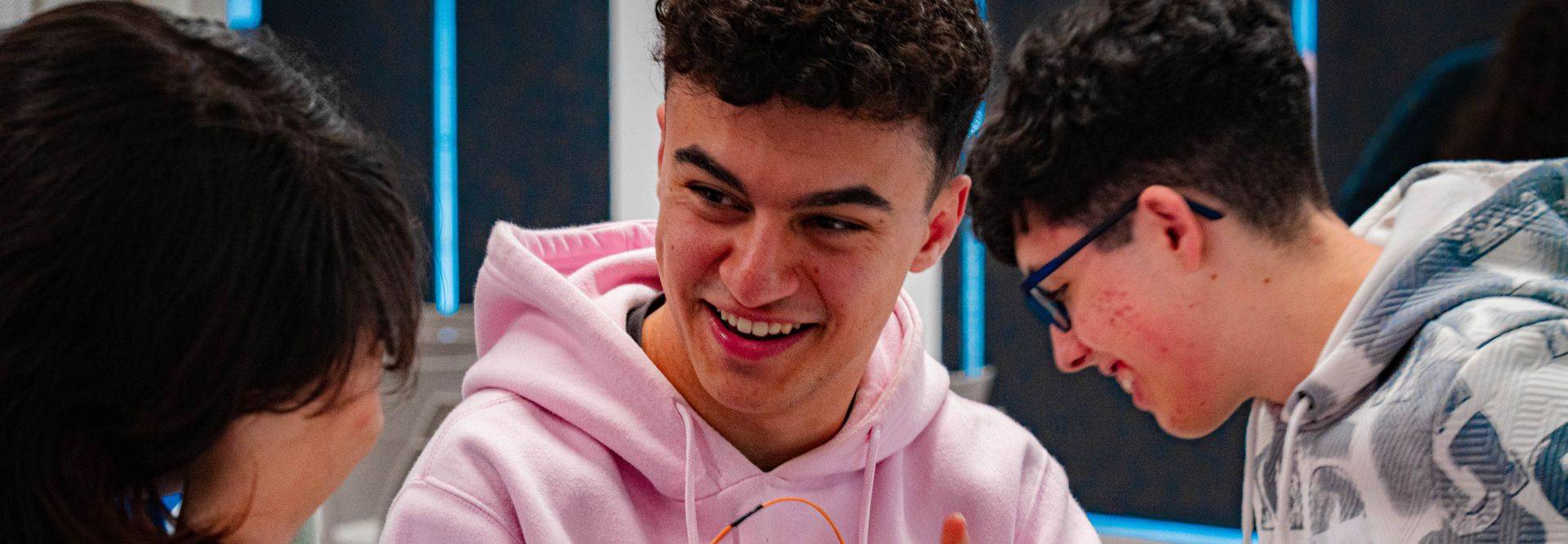 Un grupo de jóvenes conversando y riendo en un entorno educativo.