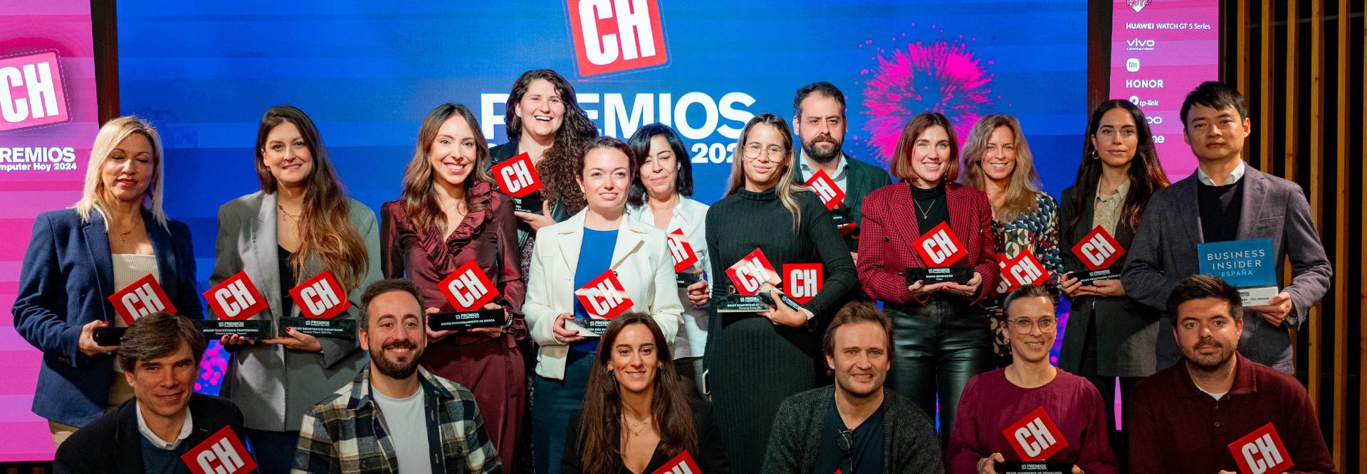 Un grupo de personas sosteniendo trofeos en un evento de premiación.
