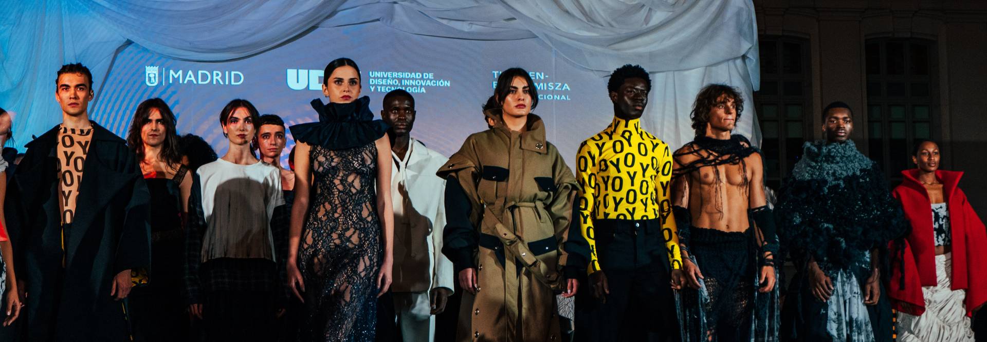 Desfile de moda con varios modelos luciendo prendas contemporáneas y creativas.