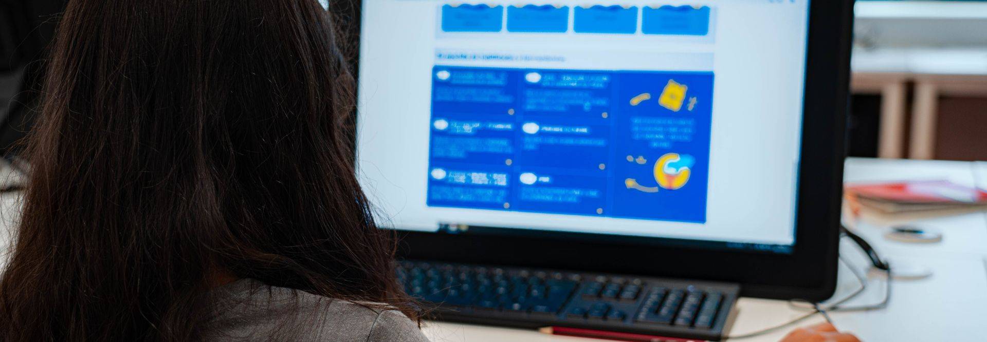 Una persona está mirando una pantalla de computadora con información visual en colores azules y gráficos.