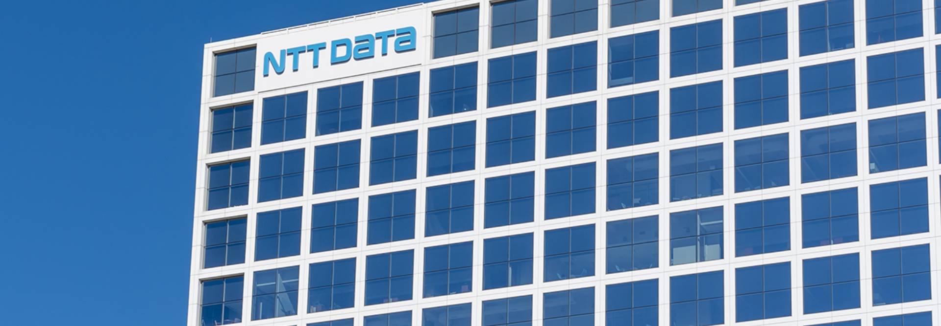 Edificio de oficinas con el logotipo de NTT Data en una fachada moderna.