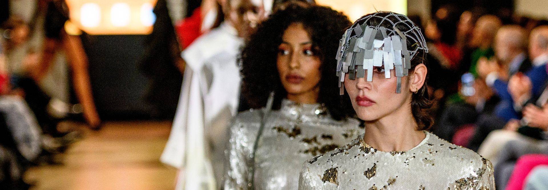 Un desfile de moda con modelos luciendo atuendos brillantes y accesorios llamativos.