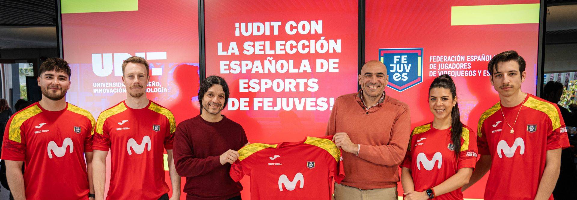Un grupo de personas presenta una camiseta con los colores de la selección española de esports.