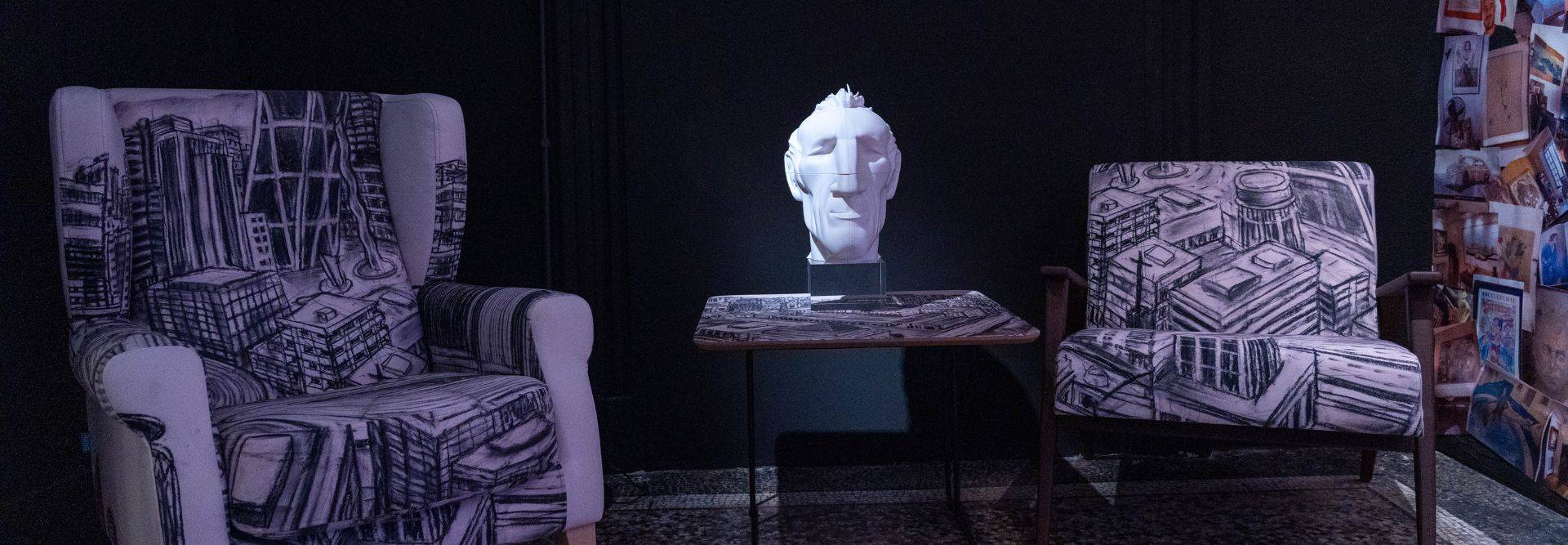 Una sala decorada con sillones y una escultura, creando un ambiente moderno.