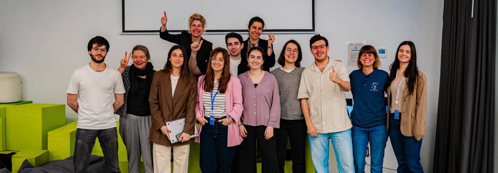 Grupo de personas sonrientes posando juntas en un entorno colorido.