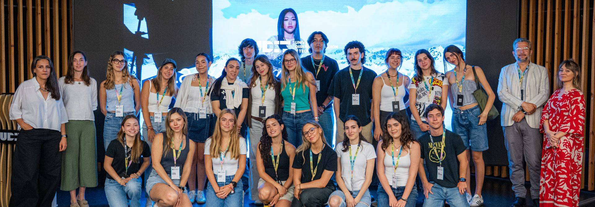 Un grupo de personas posando juntas frente a una pantalla en un evento.