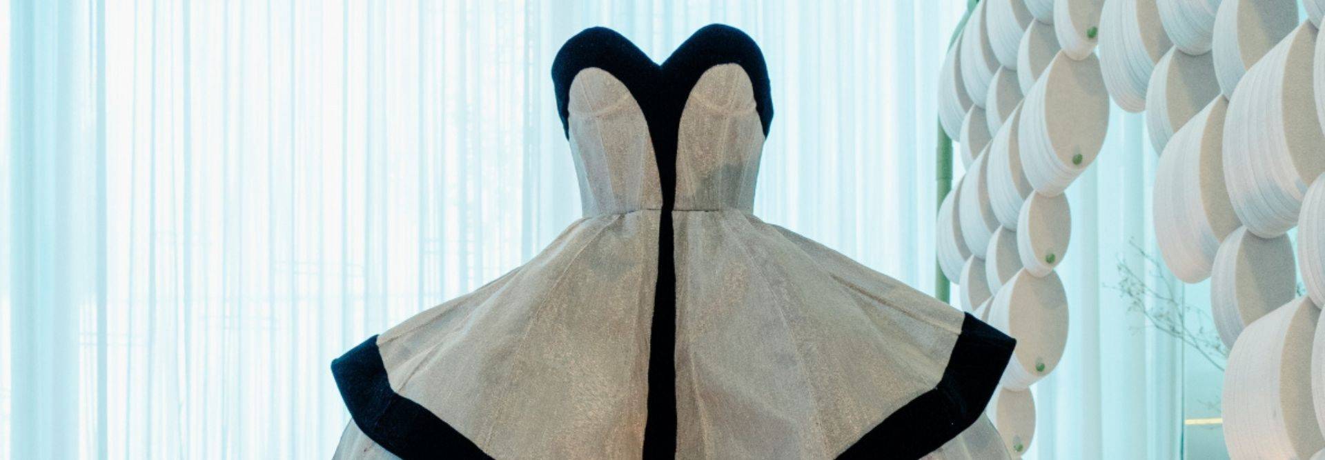 Un vestido elegante con un diseño arquitectónico y contraste en los colores blanco y negro.