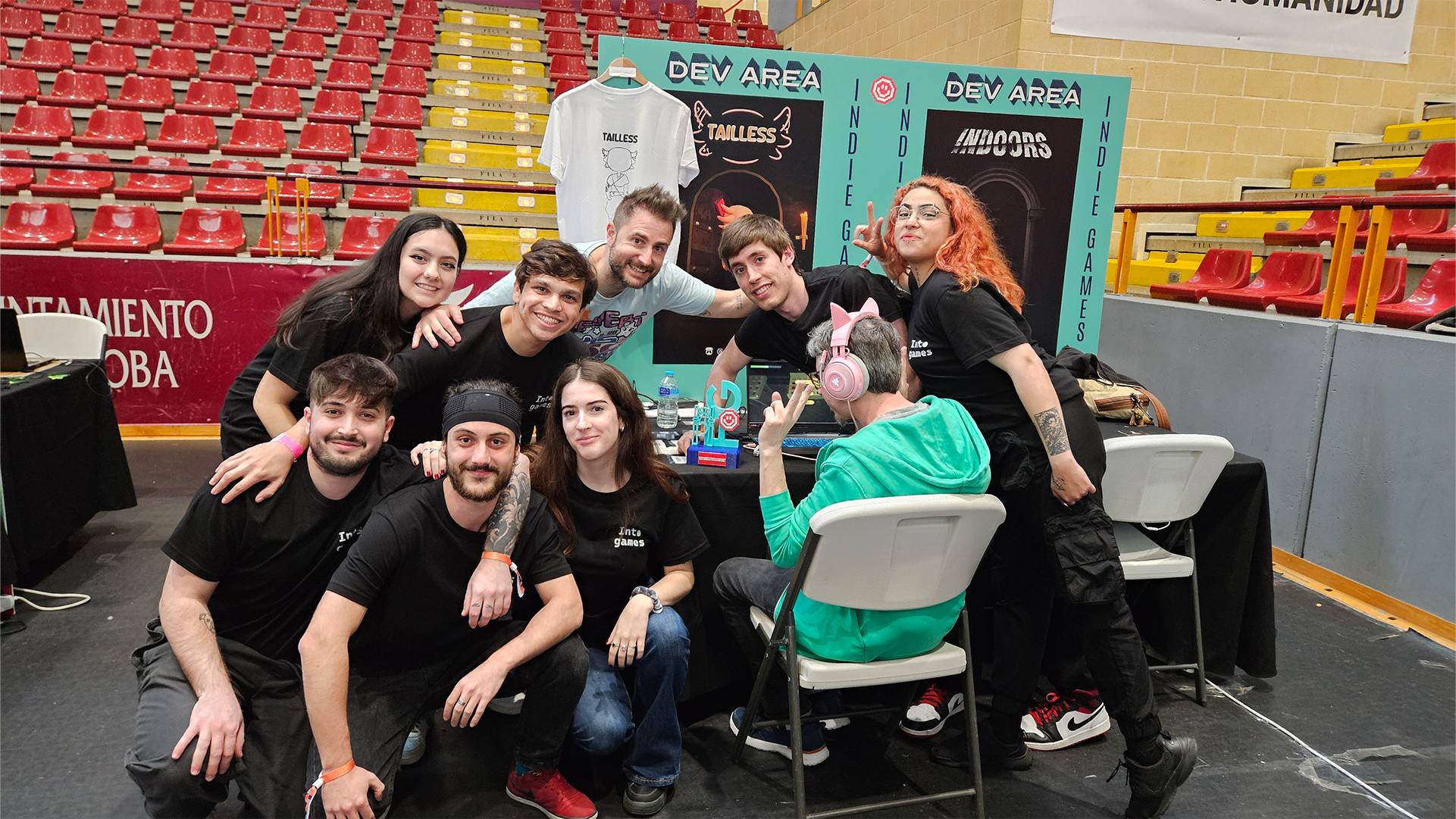 Un grupo de personas sonrientes posando en un evento, rodeados de un ambiente festivo y colorido.