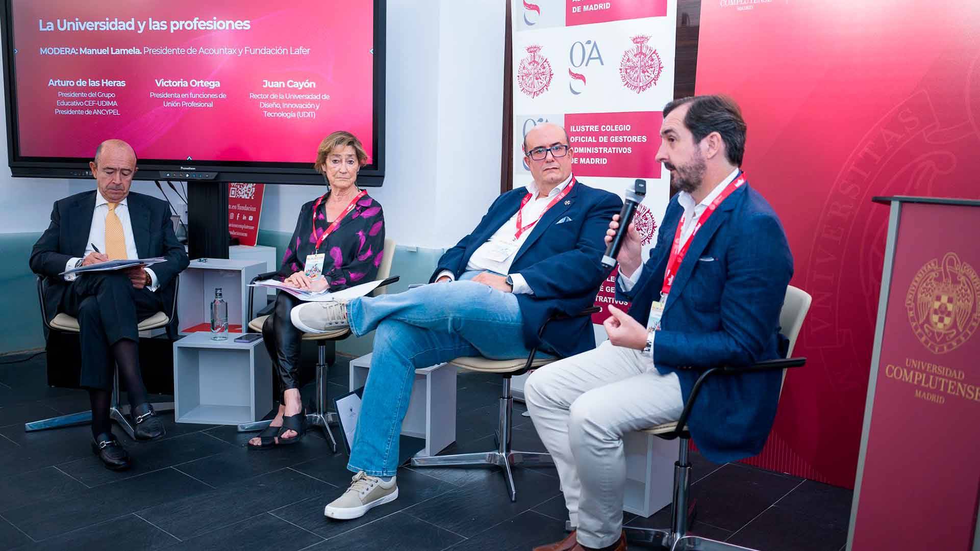 Un panel de discusión sobre la relación entre la universidad y las profesiones con varios ponentes en una mesa.