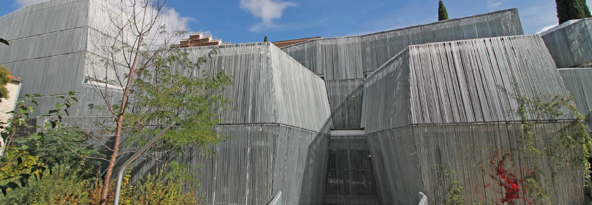 Una estructura arquitectónica moderna con un diseño angular y superficies metálicas reflejantes.