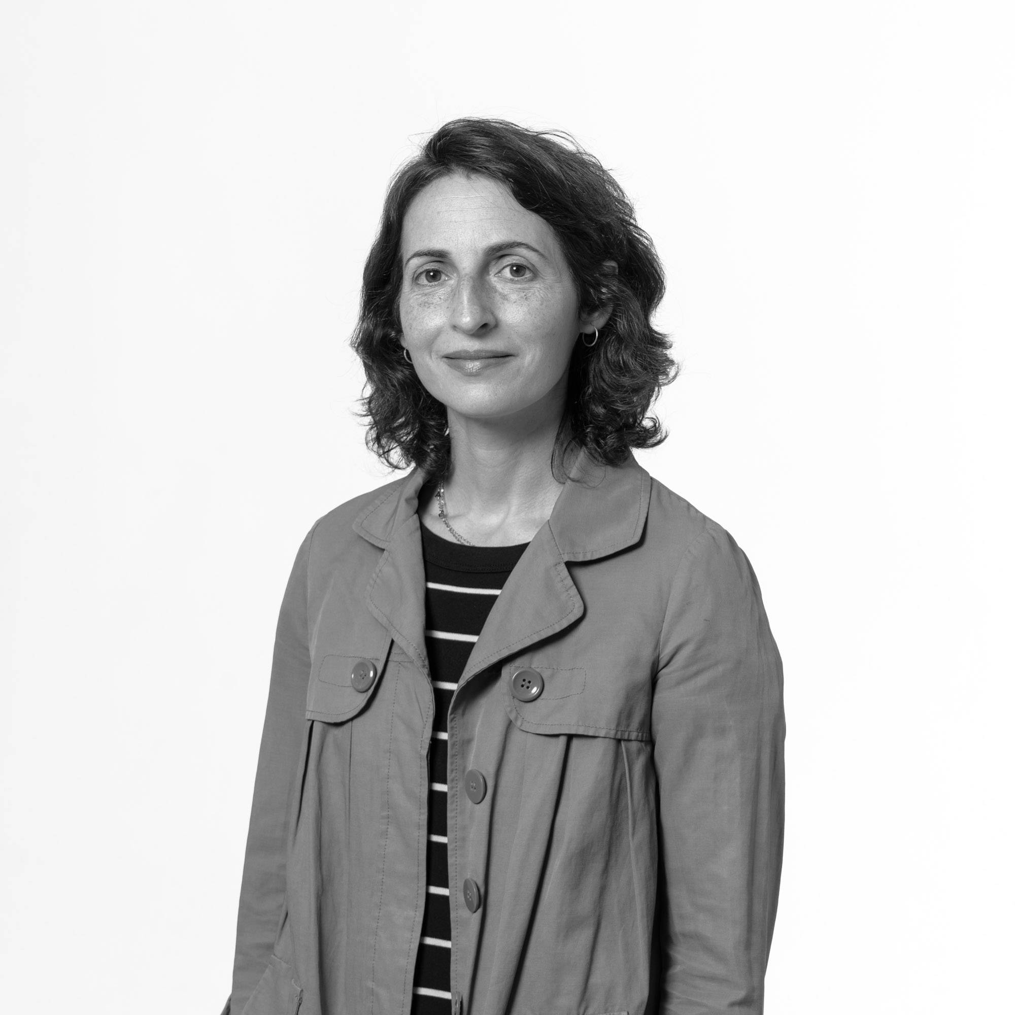 Una mujer sonriente en un retrato en blanco y negro.