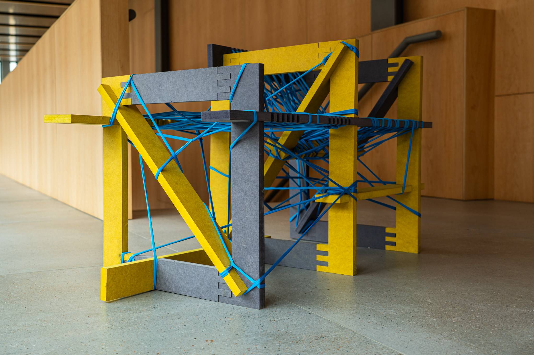 Una escultura de colores brillantes compuesta por materiales en forma de estructura geométrica.