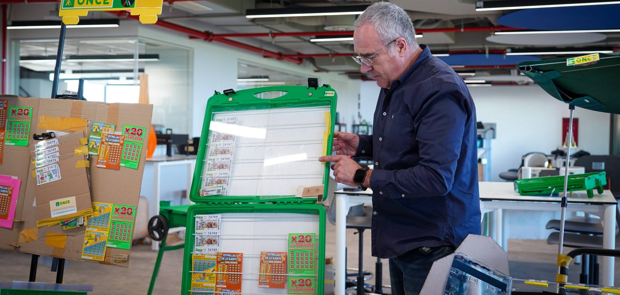 Una persona está mostrando una cartela de juegos en un ambiente de oficina moderno.