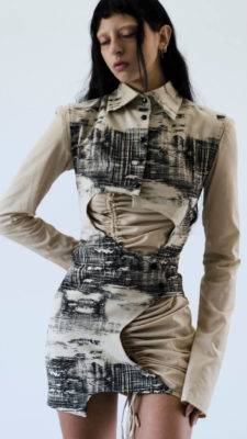 Una modelo presenta un vestido de diseño moderno con patrones abstractos en tonos beige y negro.