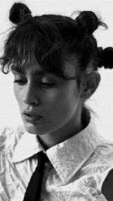Retrato en blanco y negro de una mujer con un peinado moderno y una camisa con cuello.