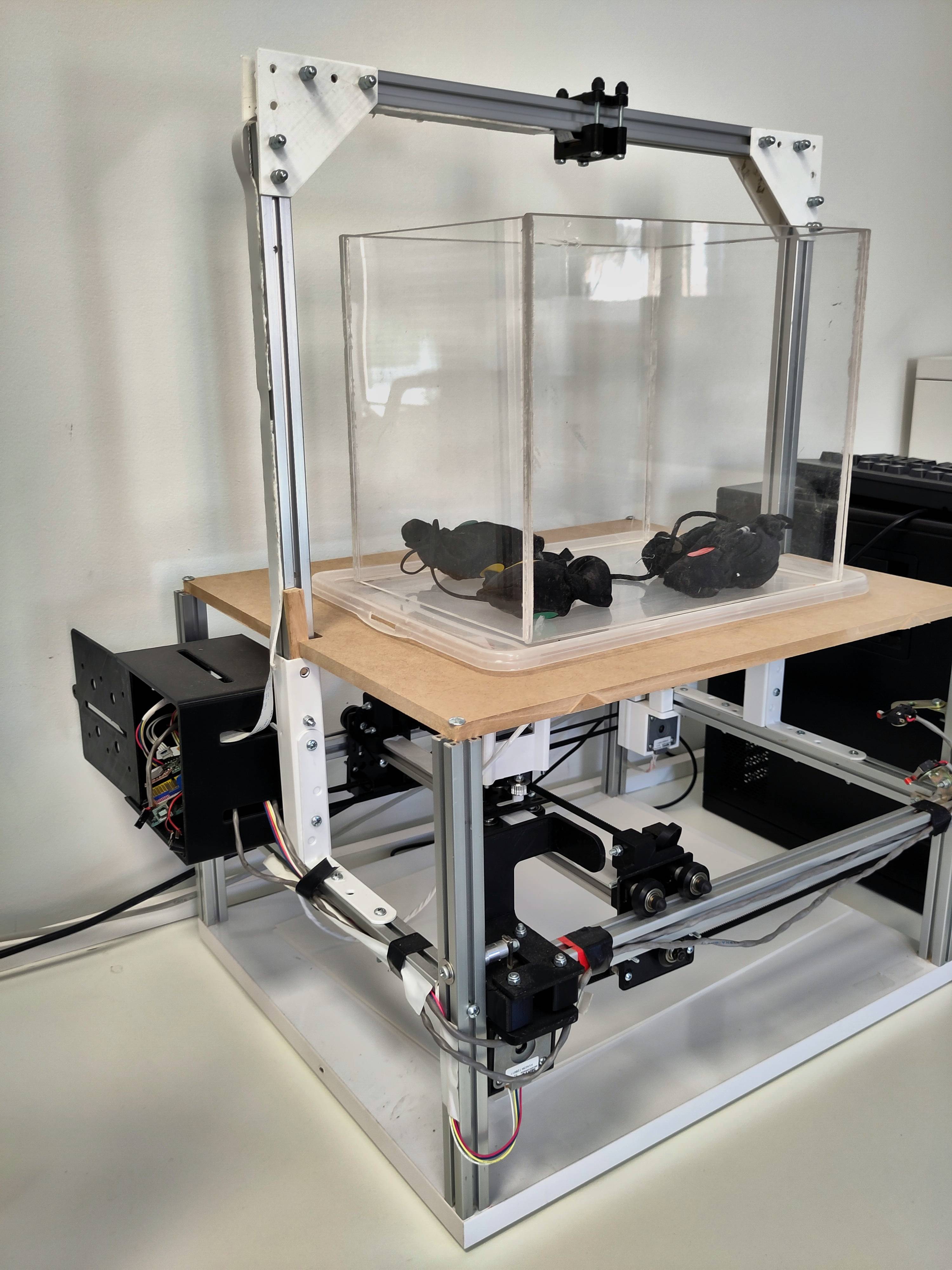 Una estructura mecánica con un contenedor transparente y componentes eléctricos visibles.