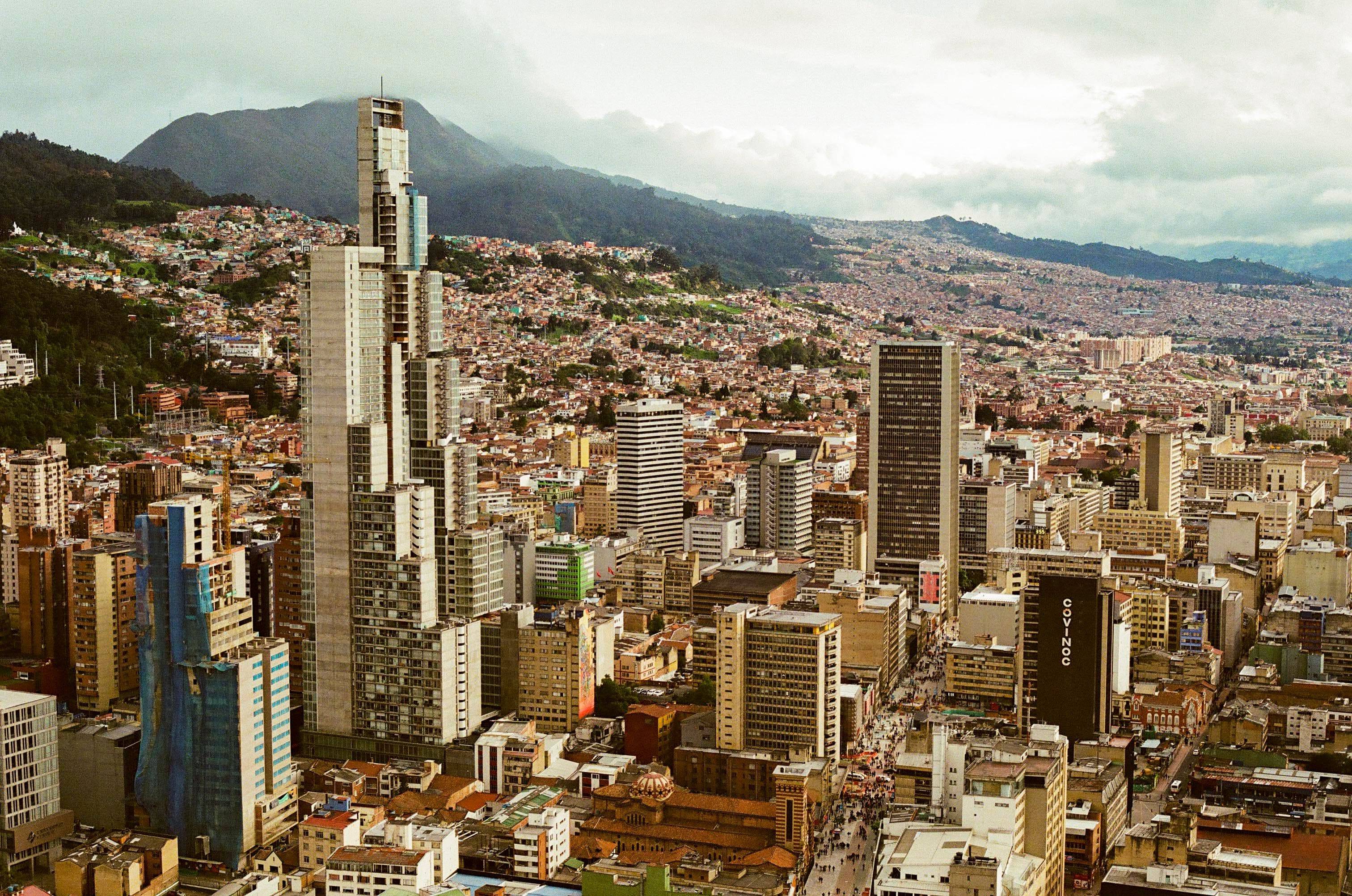 Vista panorámica de la ciudad de Bogotá con sus edificios y montañas al fondo.