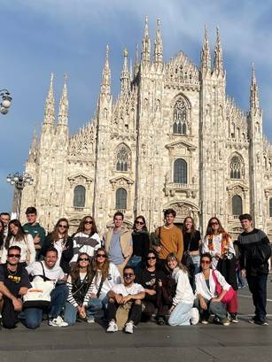 Un grupo de personas posando frente a una catedral impresionante en Milán.