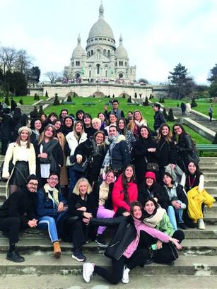 Un grupo grande de personas posando frente a la basílica del Sagrado Corazón en París.
