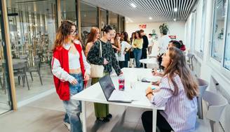 Un grupo de estudiantes en una sala moderna esperando para registrarse en un evento.