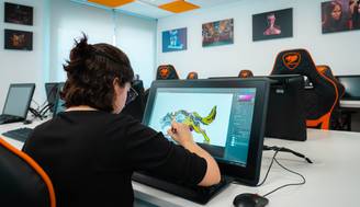 Una persona está dibujando en una tableta gráfica en un aula moderna de diseño.