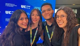 Un grupo de cuatro personas sonriendo frente a un fondo azul con el texto 'Graduación 2026'.
