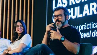 Una charla en un evento sobre las ruinas populares con dos ponentes sentados en un escenario.