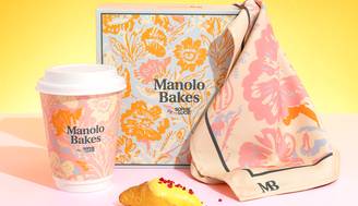 Una presentación colorida de productos de repostería, incluyendo una taza, una caja y un croissant sobre un fondo amarillo.
