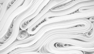 La imagen muestra una disposición de hojas de papel enrolladas y superpuestas entre sí.
