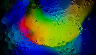 La imagen muestra una mezcla de colores vibrantes y burbujas en un fondo abstracto.