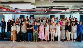 Un grupo numeroso de personas posando juntas en un ambiente moderno y luminoso.