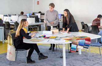 Un grupo de personas colabora en un ambiente de oficina moderno, revisando materiales y compartiendo ideas.