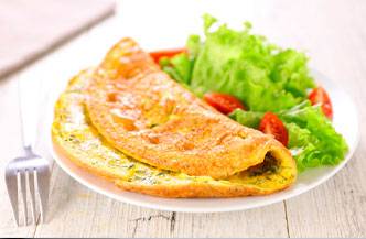 Un plato de tortilla acompañado de lechuga y tomate.