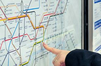Una persona señala un mapa de metro con varias líneas de colores.