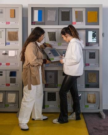 Dos mujeres revisan una muestra de materiales en la materioteca de UDIT.