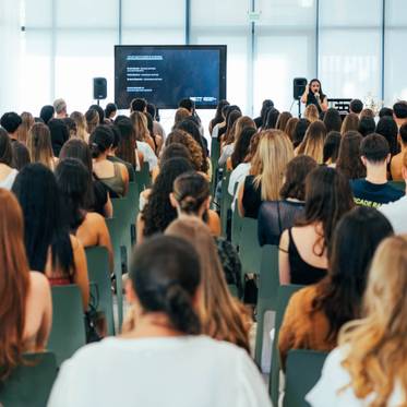 Una multitud de personas asiste a una presentación en un salón moderno.