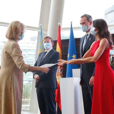 Un acto oficial donde varias personas, incluyendo a un rey, están participando en una ceremonia de entrega de un reconocimiento.