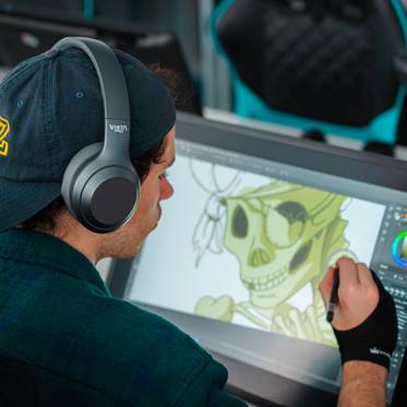 Un artista digital trabaja en una ilustración de un esqueleto en una tableta gráfica.