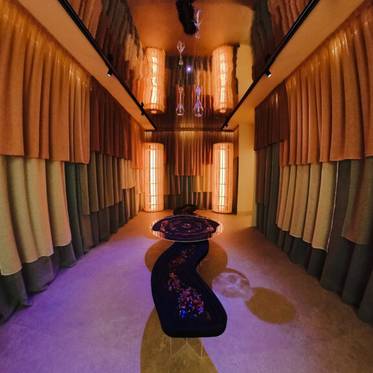 La imagen muestra una habitación moderna decorada con cortinas y luces cálidas.