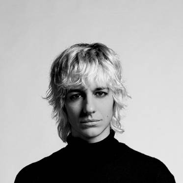 Un retrato en blanco y negro de una persona con cabello rubio y rizado.