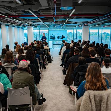 Una conferencia con un gran público en un entorno moderno y luminoso.