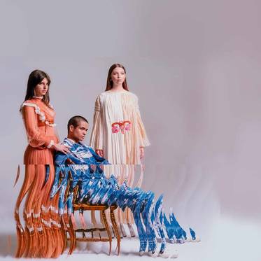 La imagen muestra a tres modelos posando en un entorno artístico con un efecto de distorsión visual.