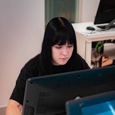 Una persona está trabajando frente a una computadora en un entorno de oficina.