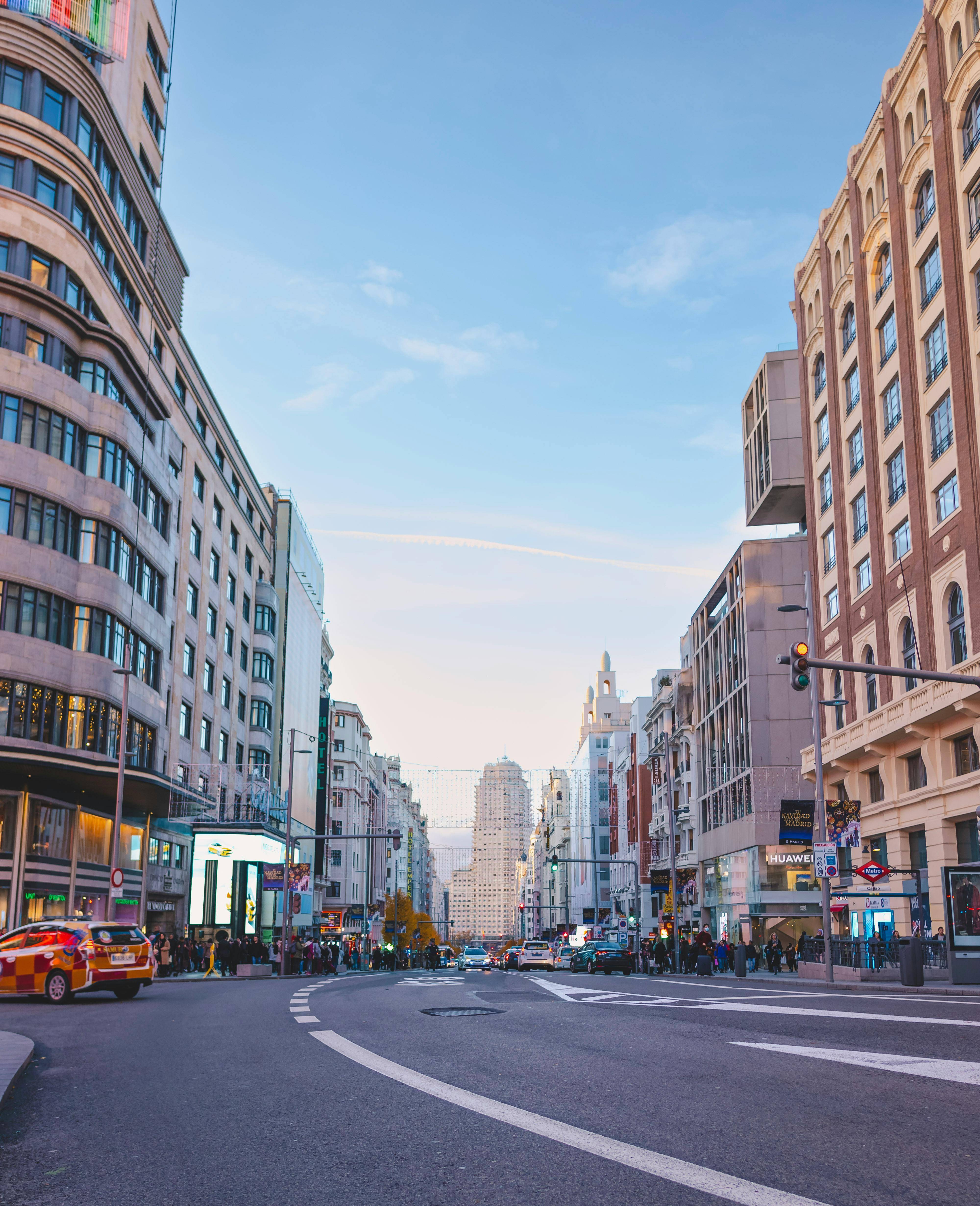 Una vista de una calle urbana con edificios altos y un cielo claro.