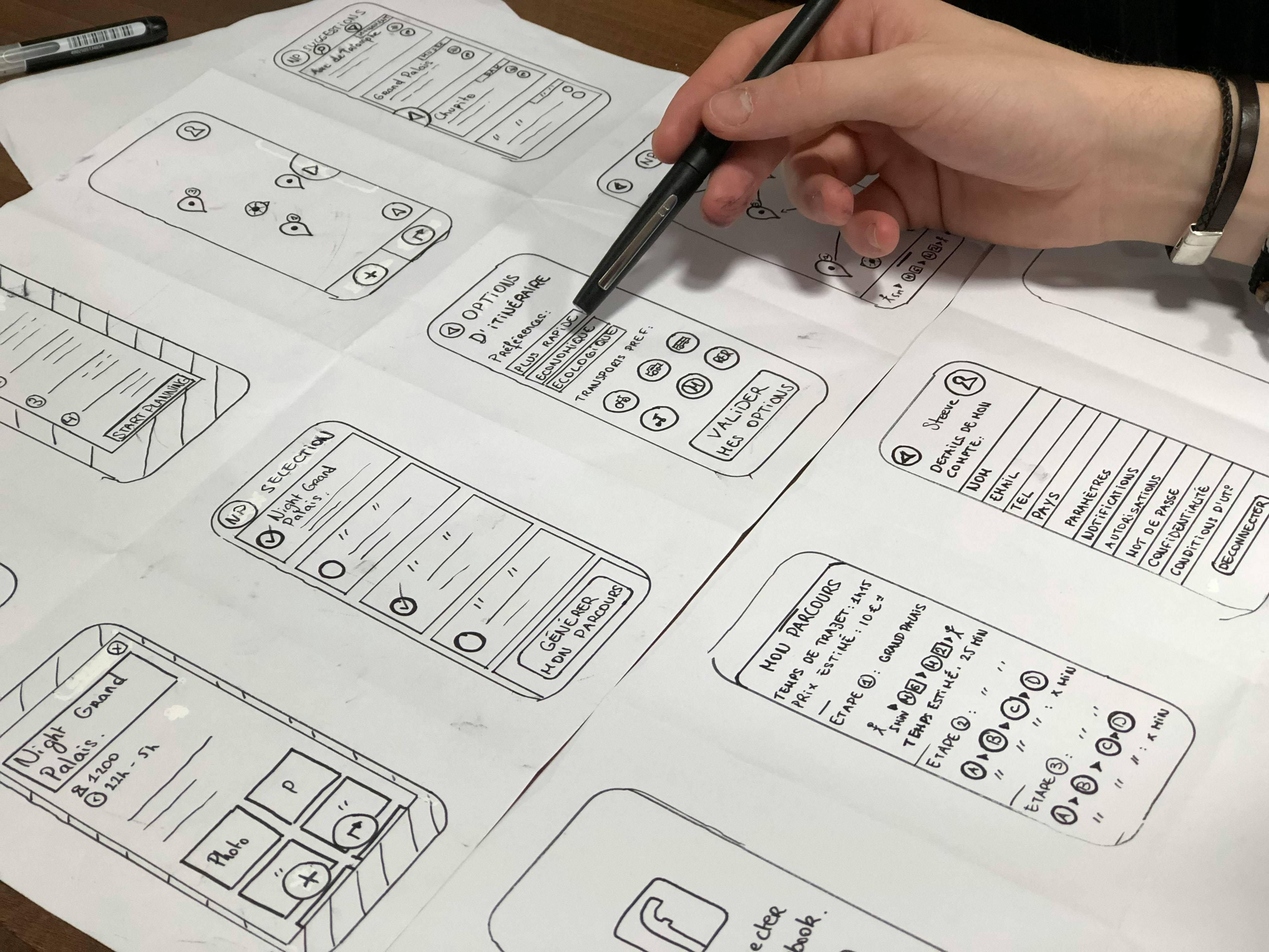 Un boceto en papel de varias pantallas de una aplicación móvil que está siendo diseñado.